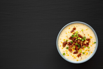 Homemade Corn Chowder with Bacon in a Bowl on a black background, top view. Flat lay, overhead, from above. Copy space.