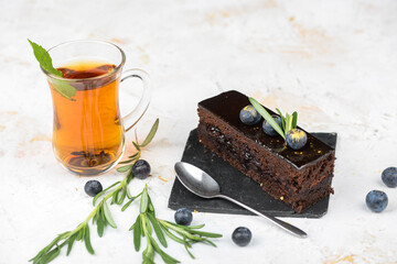 dessert chocolate cake on black slate on a white background with tea
