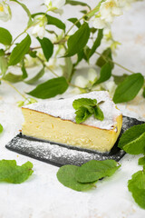 cheese cheesecake dessert on a light background with greens vertical photo
