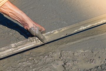 worker he is using trowel and leveling concrete on the floor of building.pouring concrete slab