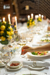 set table with a woman's hand with a glass of wine
