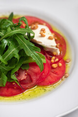 Fresh caprese salad on a white plate.