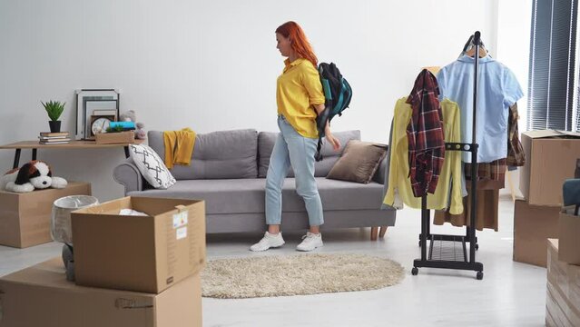 portrait of a young sad female refugee takes a backpack and a box of clothes to leave the country due to danger to life