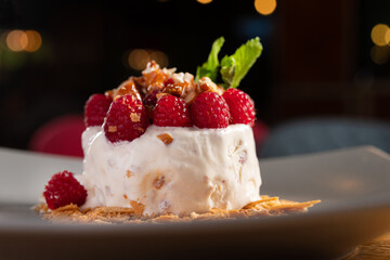 Delicious dessert of ice cream, fresh raspberries and nuts
