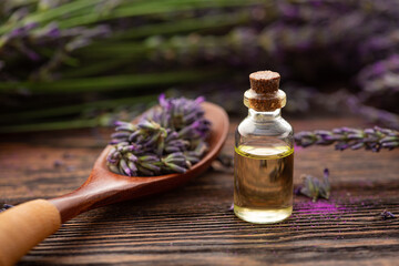 Bottle with lavender oil and a fresh bouquet of flowers