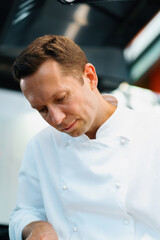 Close-up of a serious-faced chef working in a professional restaurant kitchen