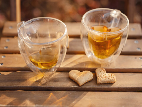 Drinking tea with cookies on wooden table. Cozy autumn mood scene in autumn park