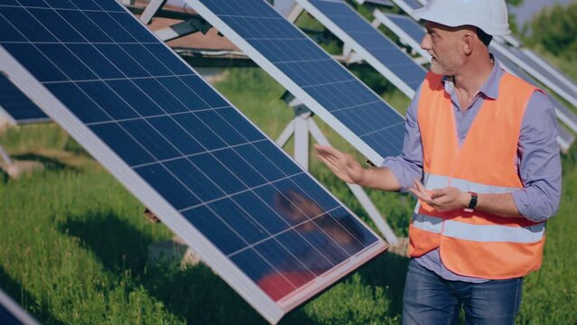 Concept of renewable energy the ecological engineer mature looking he touching slowly the photovoltaic solar panels and analysing the cleanliness of the solar panels