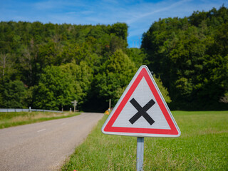 information road sign. intersections of equivalent roads. sign against the backdrop of a forest in a village in France