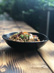 Close up view of delicious asian food. Handmade noodles with chicken and fresh ingredients and vegetables.