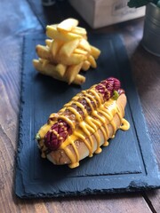 Delicious and mouth watering hot dog with cheddar cheese and potato chips as a side dish