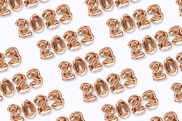 Repetitive pattern made of 2023 gold inflatable balloons on a blue background. New Year's layout.