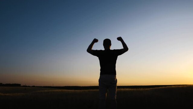 Strong powerful man flexing his arms up to the sky. Mental and physical strength concept.