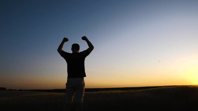 Confident man raising hands up in the air. People success, victory, and power.