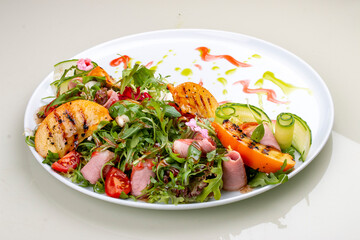 Fresh salad with ham and arugula, with grilled persimmon.