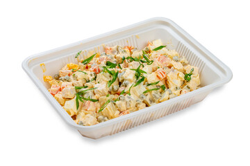 Traditional Russian salad "Olivier". In a plastic container. Food to go. On a light background.