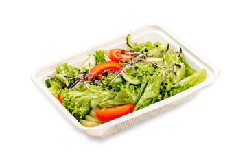 Salad with fresh vegetables and microgreens. In a plastic container. Food to go. On a light background.