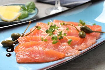 Delicious salmon carpaccio served on light grey table, closeup