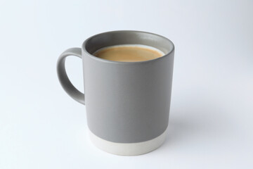 Grey mug of freshly brewed hot coffee on white background