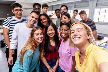 Fototapeta United multiracial big group of student friends taking selfie with teacher at college - Teenage high school people having fun together in classroom - Youth lifestyle, education and community concept obraz