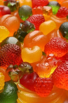 Mix of different delicious gummy candies as background, closeup
