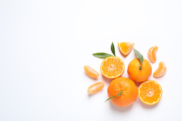Composition with fresh ripe tangerines and leaves on white background, flat lay. Citrus fruit