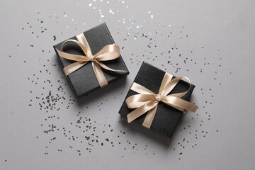 Beautiful gift boxes and confetti on grey background, flat lay