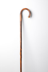 Elegant wooden walking cane on white background