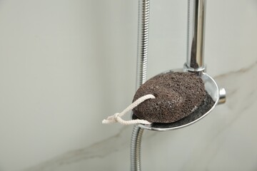Pumice stone on metal shelf in bathroom, space for text