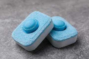Water softener tablets on grey table, closeup