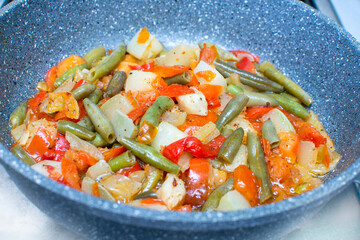 diet vegetable mixture is heated in a frying pan