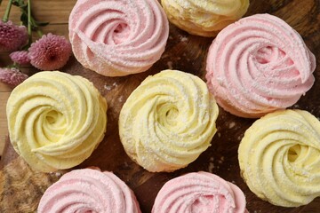 Delicious pink and yellow marshmallows on wooden table, flat lay