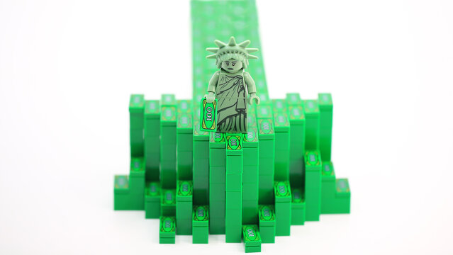 Hong Kong - July 25 2022: Statue of Liberty stand on the arrow by block of money