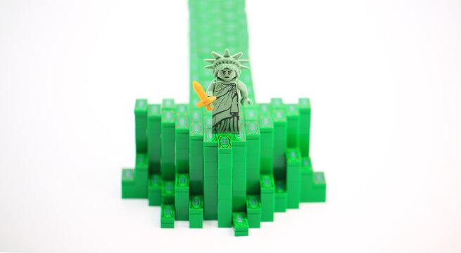 Hong Kong - July 25 2022: Statue of Liberty stand on the arrow by block of money