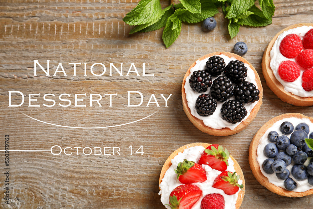 Wall mural national dessert day, october 14. tasty tartlets with different fresh berries on wooden table, flat 