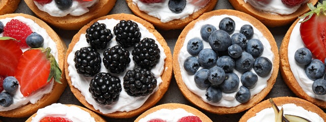 Delicious tartlets with fresh berries, top view. Banner design