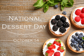 National Dessert Day, October 14. Tasty tartlets with different fresh berries on wooden table, flat lay