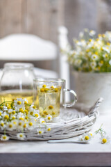 Fototapeta na wymiar cup of chamomile tea with chamomile flowers 