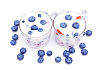 Fruit yogurt desserts in glasses on white