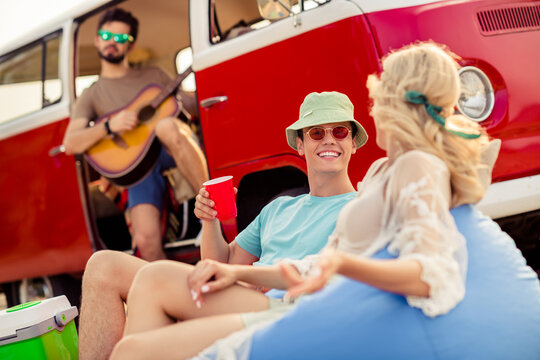 Photo of group carefree people play guitar music sit beanbag drink chatting rest relax pastime outdoors