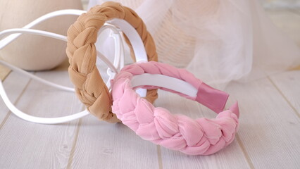 Soft pink and brown color braided headband made out of chiffon and tulle fabric texture. A hair band or headpiece with braid pattern.