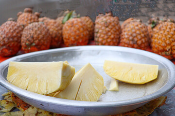 Fototapeta na wymiar ripe pineapple without peel on juice shop
