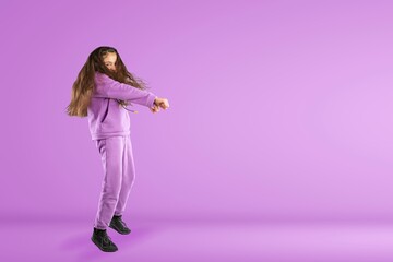 Overjoyed teen girl in fashionable clothes dance on studio background. Hobby and entertainment.