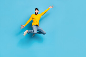 Fototapeta na wymiar Full size photo of overjoyed crazy person jumping have fun good mood empty space isolated on blue color background
