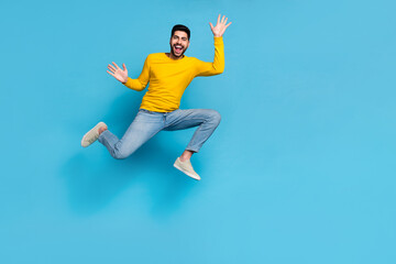Fototapeta na wymiar Full length photo of sportive energetic person jumping raise hands empty space isolated on blue color background