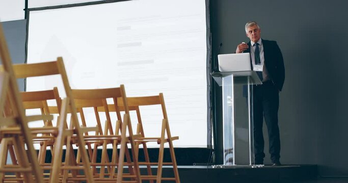 Mature manager practicing training, education and rehearsing presentation in empty seminar conference room. Confident and talking leader and speaker using screen and laptop to prepare for a workshop