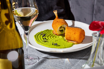 Chicken cutlet with bone and melted butter inside with pea sauce