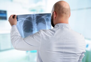 Fototapeta premium A surgeon doctor examining patient's x-ray films, scan in at radiology unit, hospital background. healthcare and medicine concept
