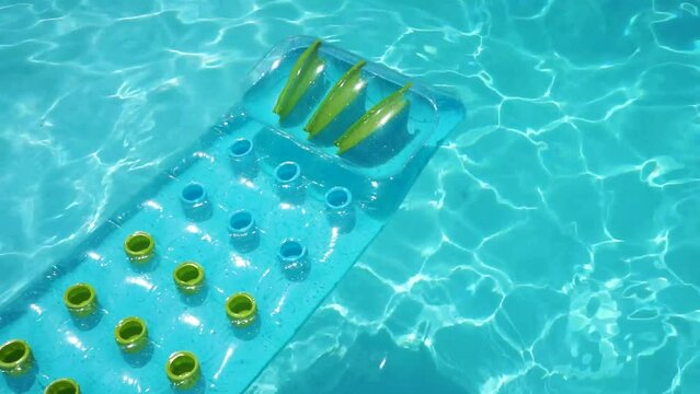 Clear blue summer pool lounger float on a rippled swimming pool