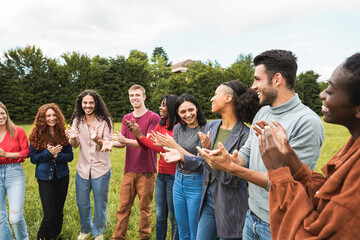 Young diverse people celebrating together outdoor - Focus on african girl wearing green shirt